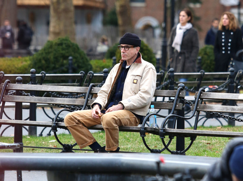 Retired actor Daniel Day-Lewis sits alone at a park bench and goes unnoticed by pedestrians in New York City.